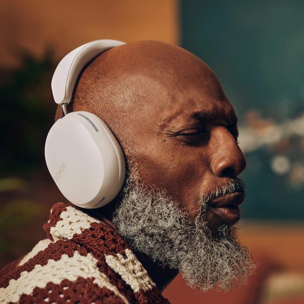 Férfi zenét hallgat fehér Sonos Ace fejhallgatón